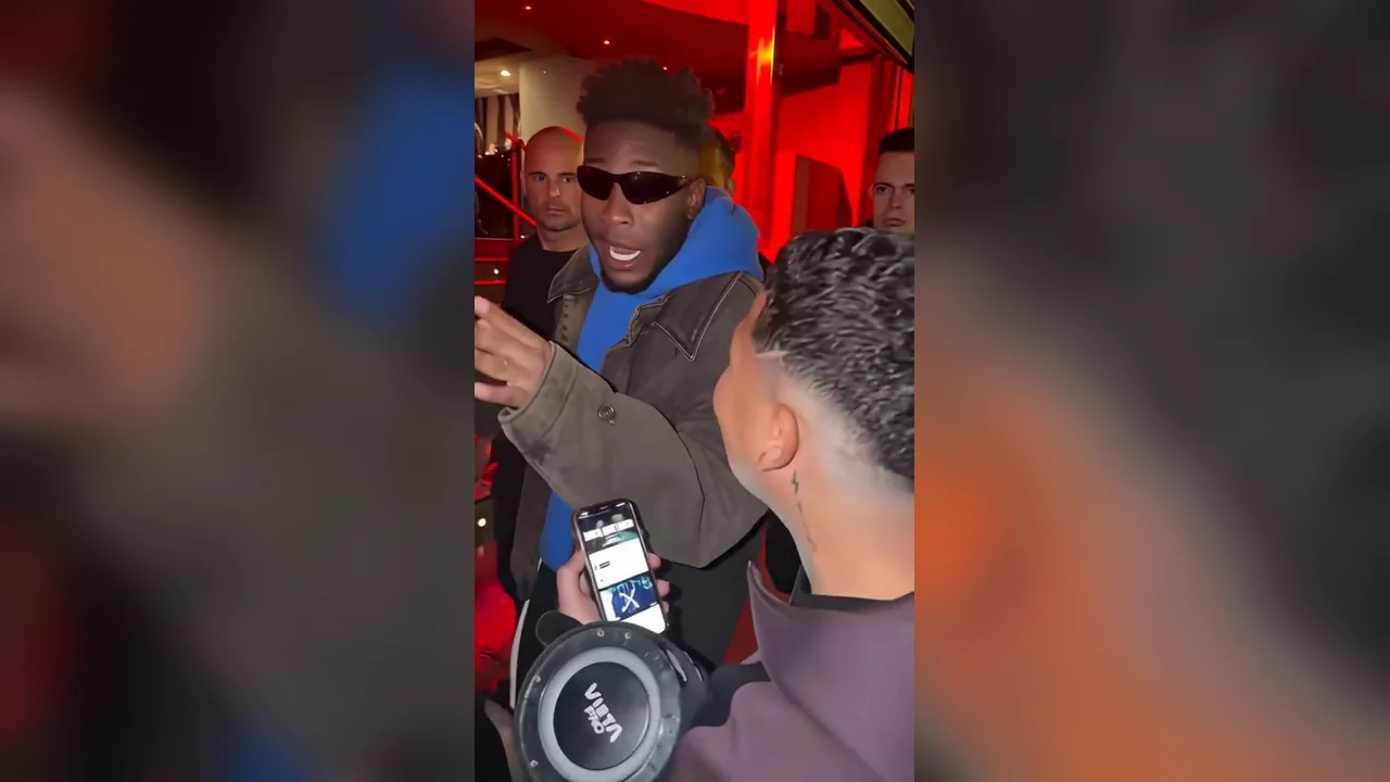 The original freestyler at the red-lit doorway, with the crowd around him